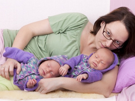 Mãe deitada com seus bebês gêmeos - Dirk Ott / Shutterstock